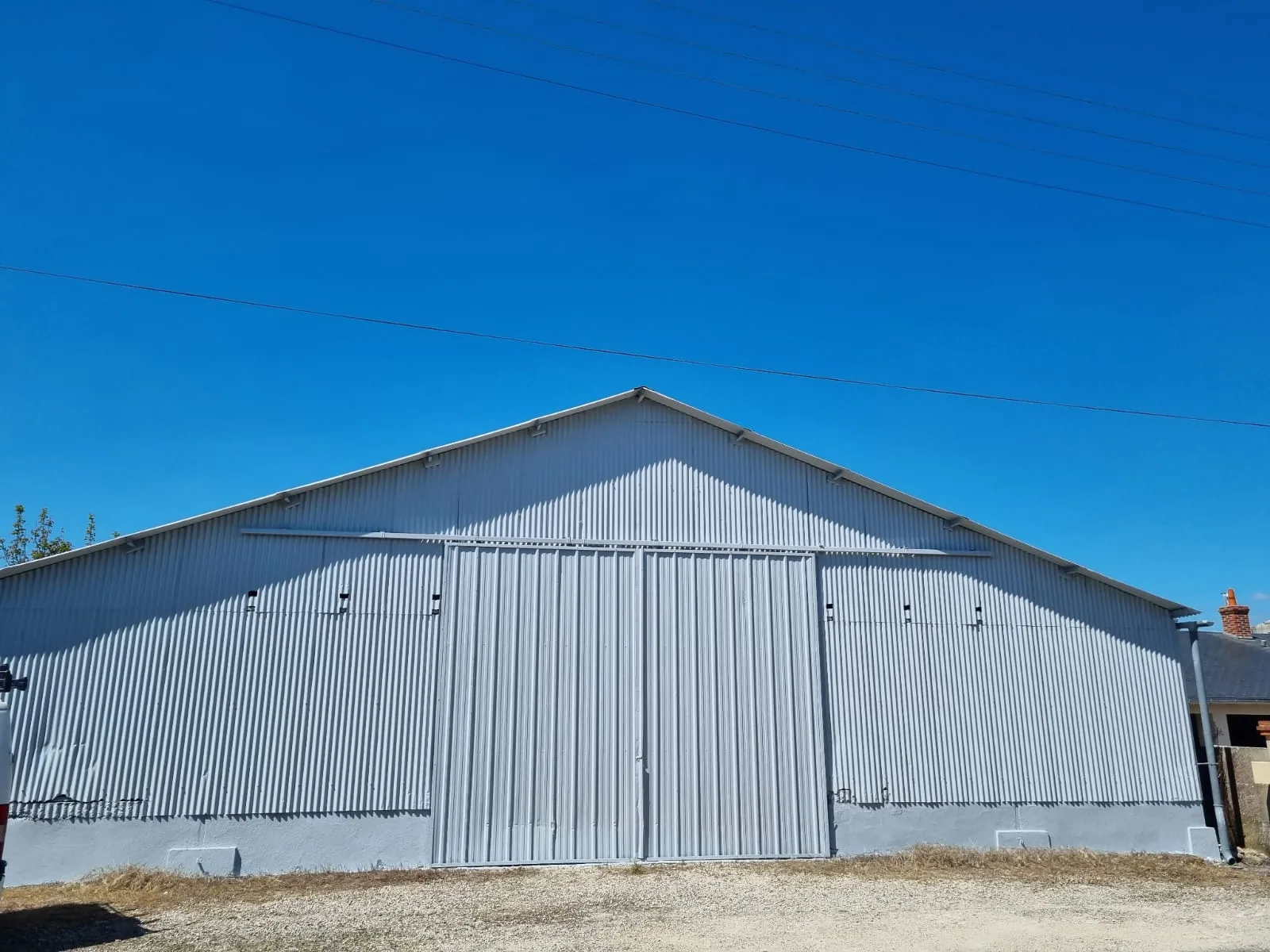 Après — Hangar agricole en tôle ondulée nettoyé et repeint en gris